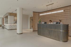 a lobby with two people sitting at a counter at Intelier Malvarrosa Plaza in Valencia