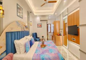 a bedroom with a bed with a blue head board at Atlantiis Suites By Signature StayZ Girjaghar Near Vishwanath Temple in Varanasi