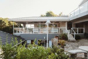 a house with a balcony and a patio at Treetops, Amblewood Guesthouse in Kenton on Sea