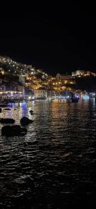a city lit up at night with a body of water at Da zio Totò in Scilla