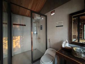 a bathroom with a shower and a toilet and a mirror at Lam Ecolodge Mu Cang Chai in Nam Khat +55 photos