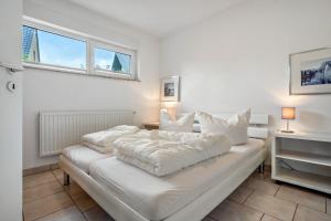 a white bed in a room with a window at Haus 44 in Röbel