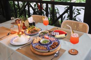 a table with plates of food and drinks on it at Lampang River Retreat in Lampang