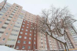 ウファにあるU Megapolisa Apartmentの建物前の雪に覆われた木