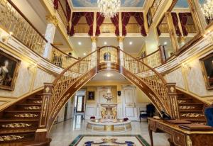 an ornate staircase in a mansion with a chandelier at Royal Boutique Hotel, Greater Vancouver in Surrey