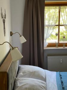 a bedroom with a bed with a lamp and a window at Juifen in Lenggries