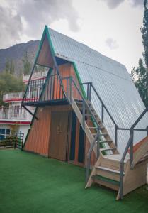 a large building with a metal roof and a staircase at Biafo Resort Skardu in Skardu