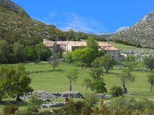 an old house in a field with mountains in the background at Le gîte panda saint-maymes in Trigance