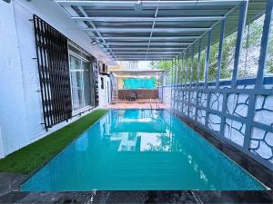 an indoor swimming pool with blue water in a building at Chikku 4 bhk villa in Lonavala