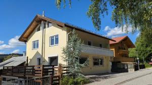 a house with a wooden fence in front of it at Forest Lodge - perfekt für Familien und Freunde in Bayerisch Eisenstein