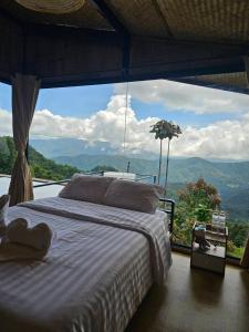 a bedroom with a bed in front of a large window at Mon Ngo misty haven B4 in Ban Mae Ta Man