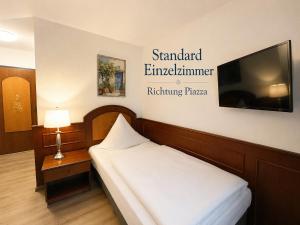 a hotel room with a bed and a flat screen tv at Hotel Garni Italia in Bühl