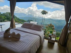 a bedroom with a bed with a view of the mountains at Mon Ngo misty haven B4 in Ban Mae Ta Man