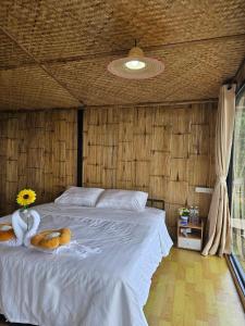 a bedroom with a large white bed with a flower on it at Mon Ngo misty haven B4 in Ban Mae Ta Man