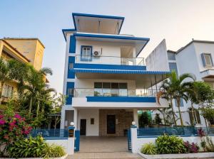 a blue and white building with palm trees at Chikku 4 bhk villa in Lonavala