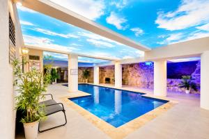 a swimming pool in a house with a ceiling at וילה לוזון - וילה מדהימה עם בריכה פרטית מחוממת ומקורה בכרם בן זמרה in Kerem Ben Zimra