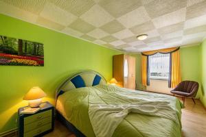 a green bedroom with a bed and a chair at Ferienwohnung Stoll in Brüel in Brüel