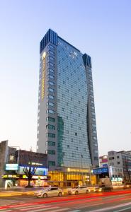 un edificio alto con coches estacionados frente a él en Hotel The Designers Seoul Station en Seúl