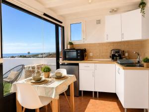 a kitchen with white cabinets and a table at Pico Colorao Loft in Soo