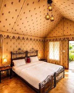 a bedroom with a large bed in a room at Sam Sand Dunes Camps Jaisalmer in Sām