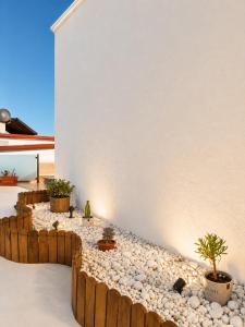 a garden with rocks and potted plants on a wall at Pico Colorao Loft in Soo