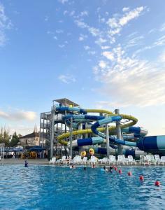 a water slide in a pool with people in the water at Hotel Zerbulaq in Taraz