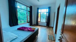 a bedroom with a bed with a purple pillow on it at North Sky Stays Bir in Bīr +3 photos