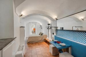 a room with a bed and a blue table at Starhost - RICORDO DEL CAPITANO, Atrani hidden gem Walking distance from Amalfi & Beach in Atrani