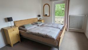 a bedroom with a bed and a window at Forest Lodge - perfekt für Familien und Freunde in Bayerisch Eisenstein