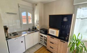 a small kitchen with a sink and a microwave at Appartement, Calme, Cosy et Balcon in Châteauroux