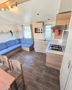 a kitchen and living room with a blue couch at Parc St Vincent in La Celle-sous-Gouzon