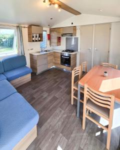 a kitchen and dining room with a blue couch and a table at Parc St Vincent in La Celle-sous-Gouzon +4 photos