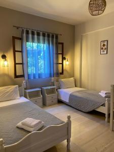a bedroom with two beds and a window at Olga Studios in Tsagarada