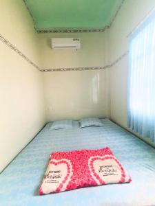 a bedroom with a bed with two signs on it at Đào Huỳnh Motel in Nam Du