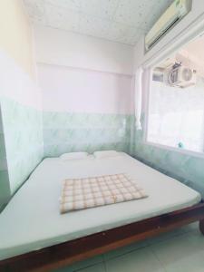 a bed in a room with a window at Đào Huỳnh Motel in Nam Du
