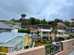 a view of a city from a balcony of houses at Nilgiris Stayz - Home Stay at Ooty in Ooty +21 photos