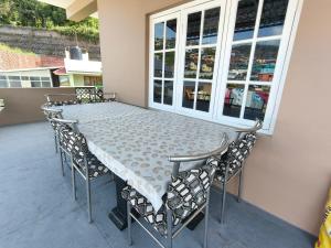 a table and chairs sitting on a patio at Nilgiris Stayz - Home Stay at Ooty in Ooty