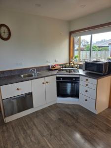 a kitchen with a stove and a sink and a microwave at Annie's in Methven