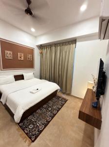 a bedroom with a bed and a flat screen tv at Sofitel Caravanserai 1BHK Noida, Spectrum Mall Sector 75 in Noida +36 photos
