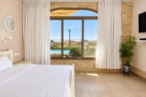 a bedroom with a bed and a large window at וילה לוזון - וילה מדהימה עם בריכה פרטית מחוממת ומקורה בכרם בן זמרה in Kerem Ben Zimra +23 photos