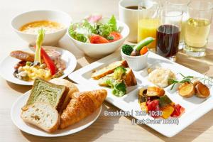 a table with plates of breakfast foods and drinks at Hotel Intergate Tokyo Kyobashi in Tokyo