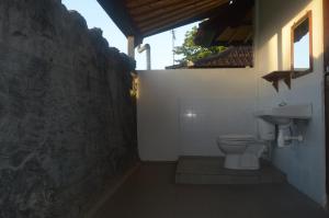a bathroom with a toilet and a sink at Kangkung Cottages in Jasri