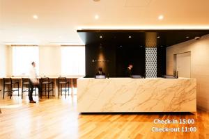 a lobby with a counter and a bar with stools at Hotel Intergate Tokyo Kyobashi in Tokyo