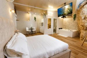 a bedroom with a bed and a tub and a sink at וילה לוזון - וילה מדהימה עם בריכה פרטית מחוממת ומקורה בכרם בן זמרה in Kerem Ben Zimra