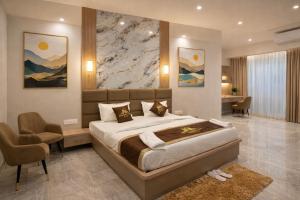 a bedroom with a large bed and a desk at Hotel Atlantiis Suites By Signature StayZ Rathyatra Near Vishwanath Temple in Varanasi