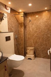 a bathroom with a toilet and a glass shower at Hotel Atlantiis Suites By Signature StayZ Rathyatra Near Vishwanath Temple in Varanasi