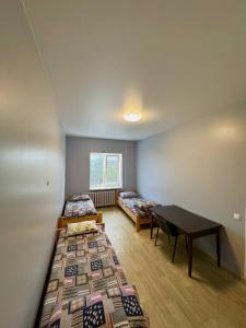 a room with two beds and a table in it at Хостел in Sumy