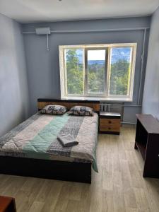 a bedroom with a bed and two windows at Хостел in Sumy