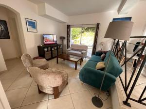 a living room with a blue couch and chairs at Villa du Bonheur Carambole in Saint-Georges-dʼOléron