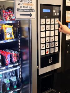 a drink vending machine with a sign on it at Quick Palace Saint Brieuc in Tregueux